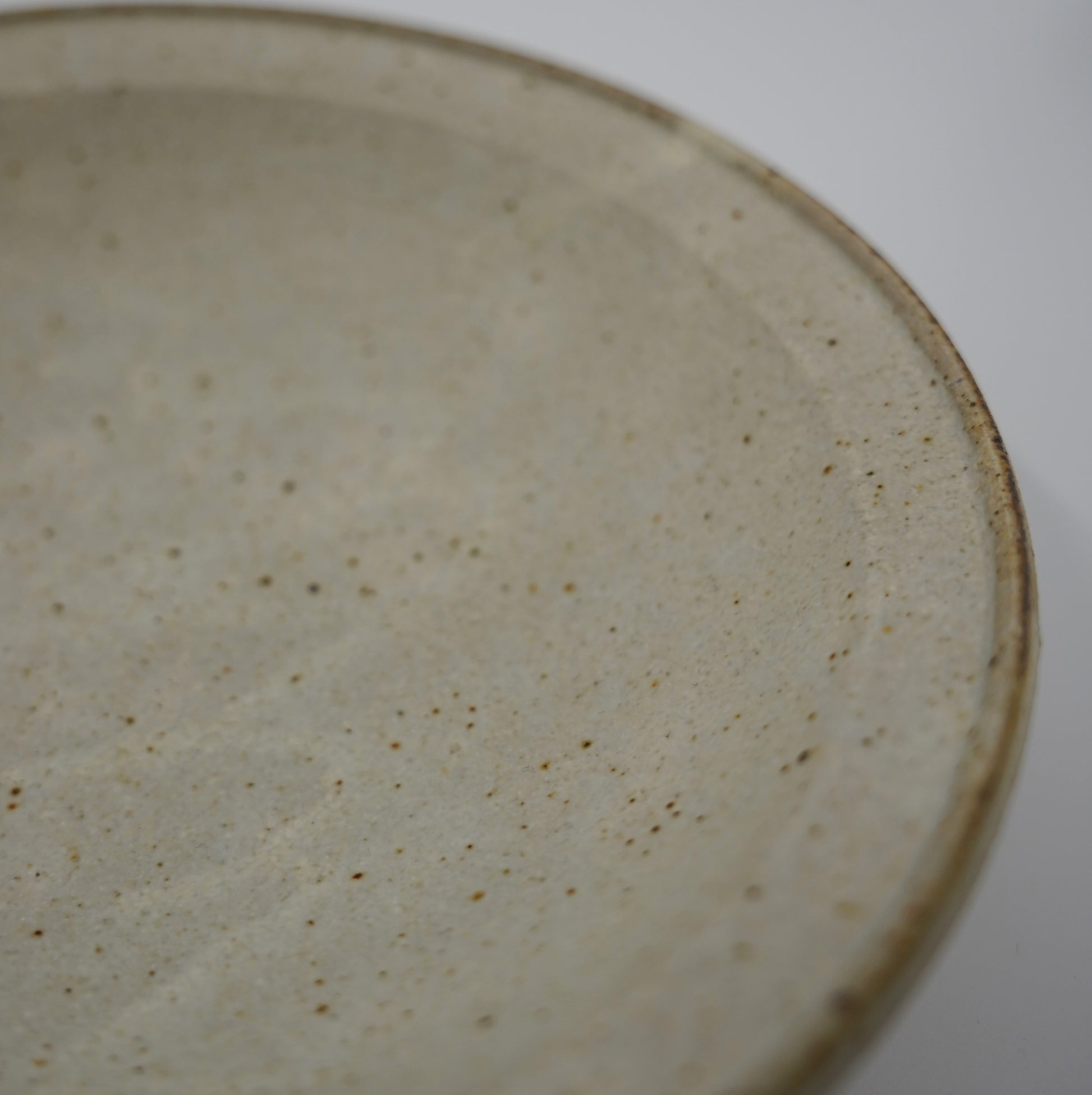 Close-up of a ceramic plate with a textured surface on a white background