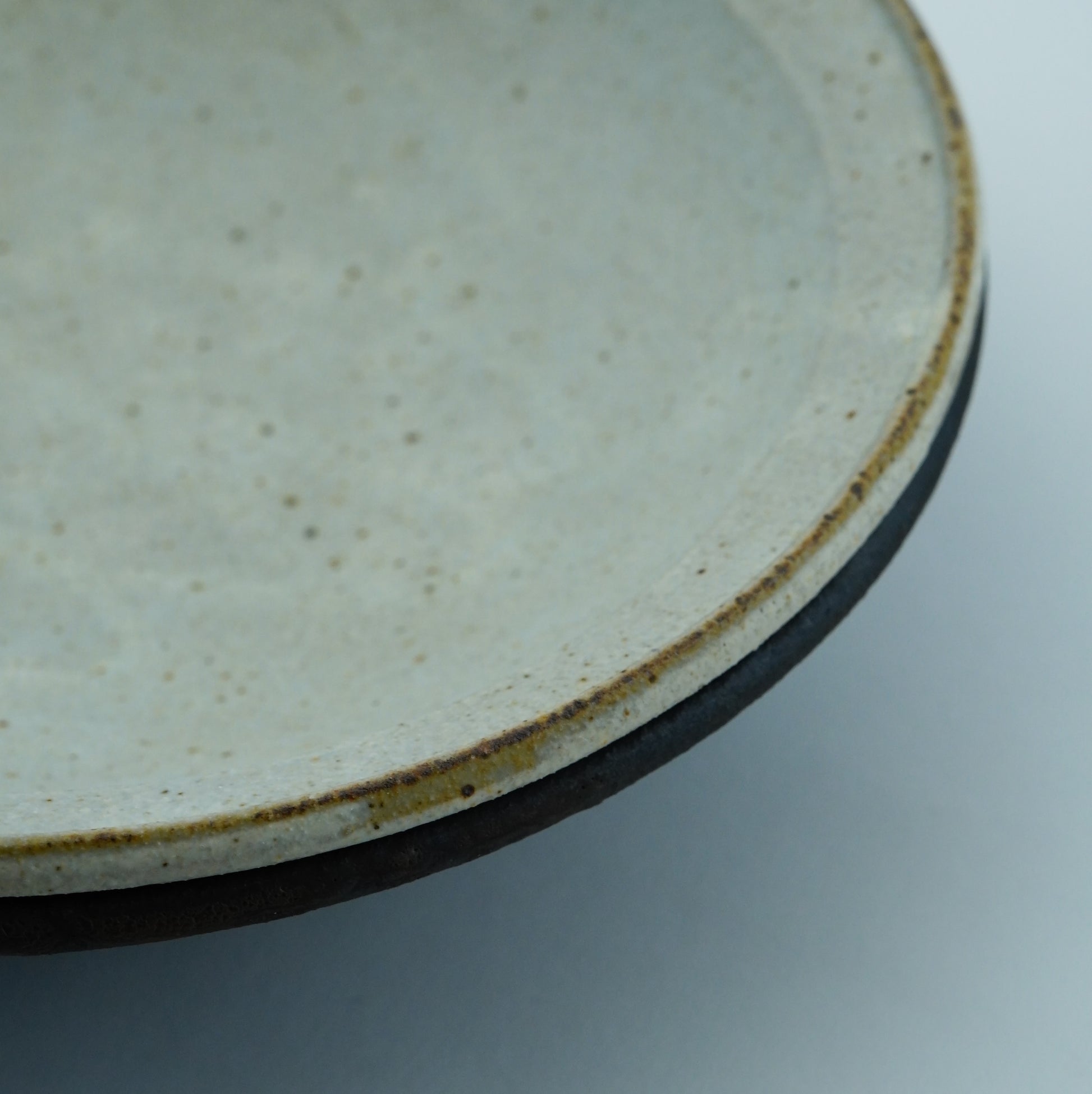 Close-up of a ceramic plate with a textured surface on a light gray background