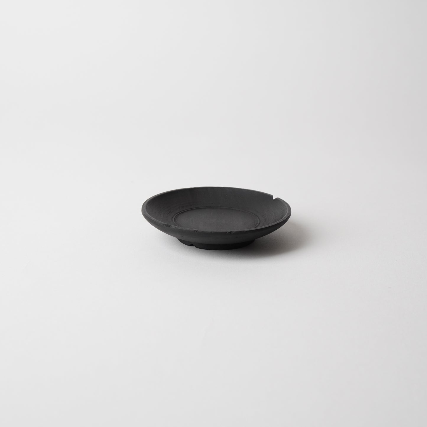 Black  wooden saucer on a white background. Handmade wooden saucer by Japanese artist at Gallery tete Hong Kong.