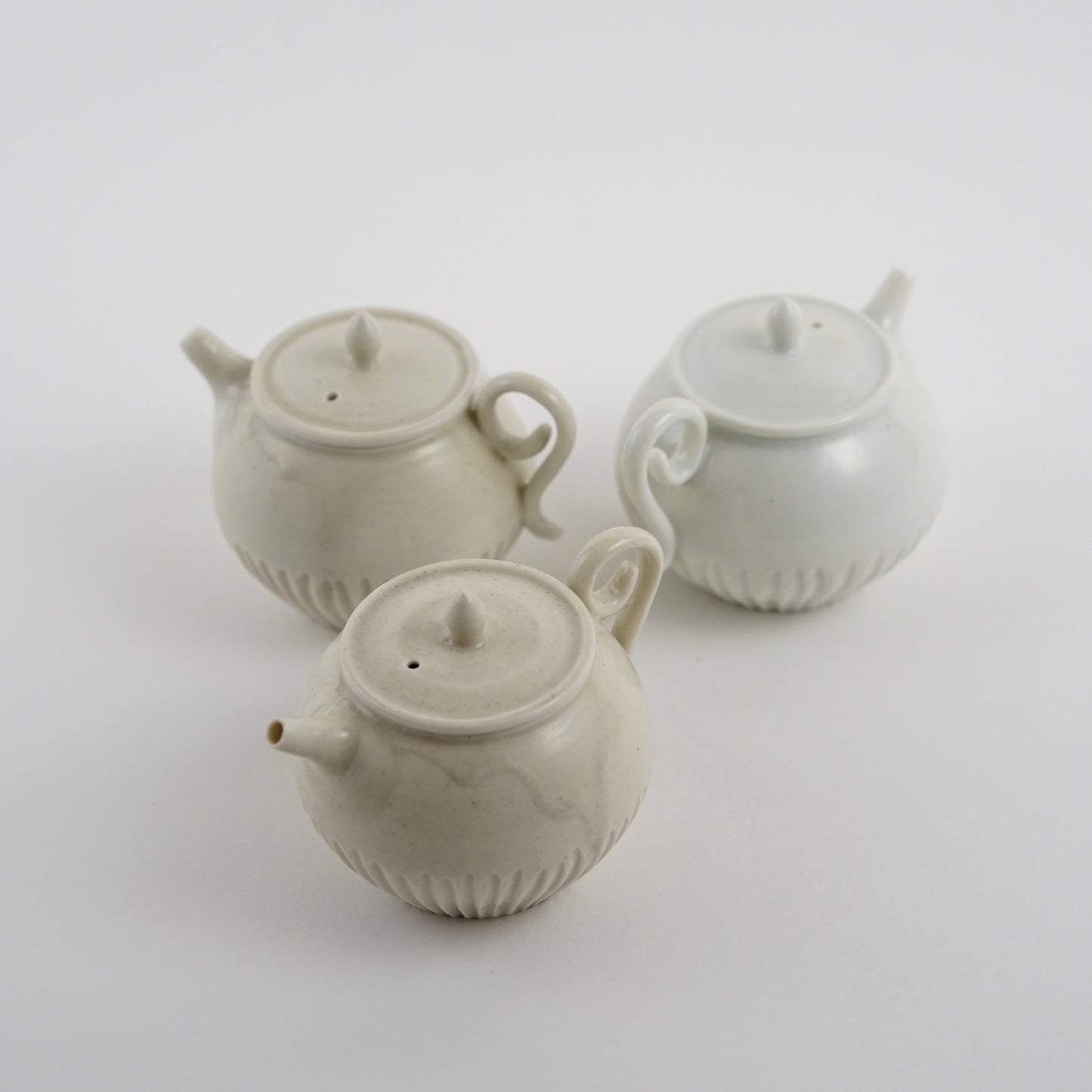 Three ceramic Chinese teapots made by Japanese Artist on a white background. Handmade porcelain chinese teapot by Japanese artist at Gallery tete Hong Kong.