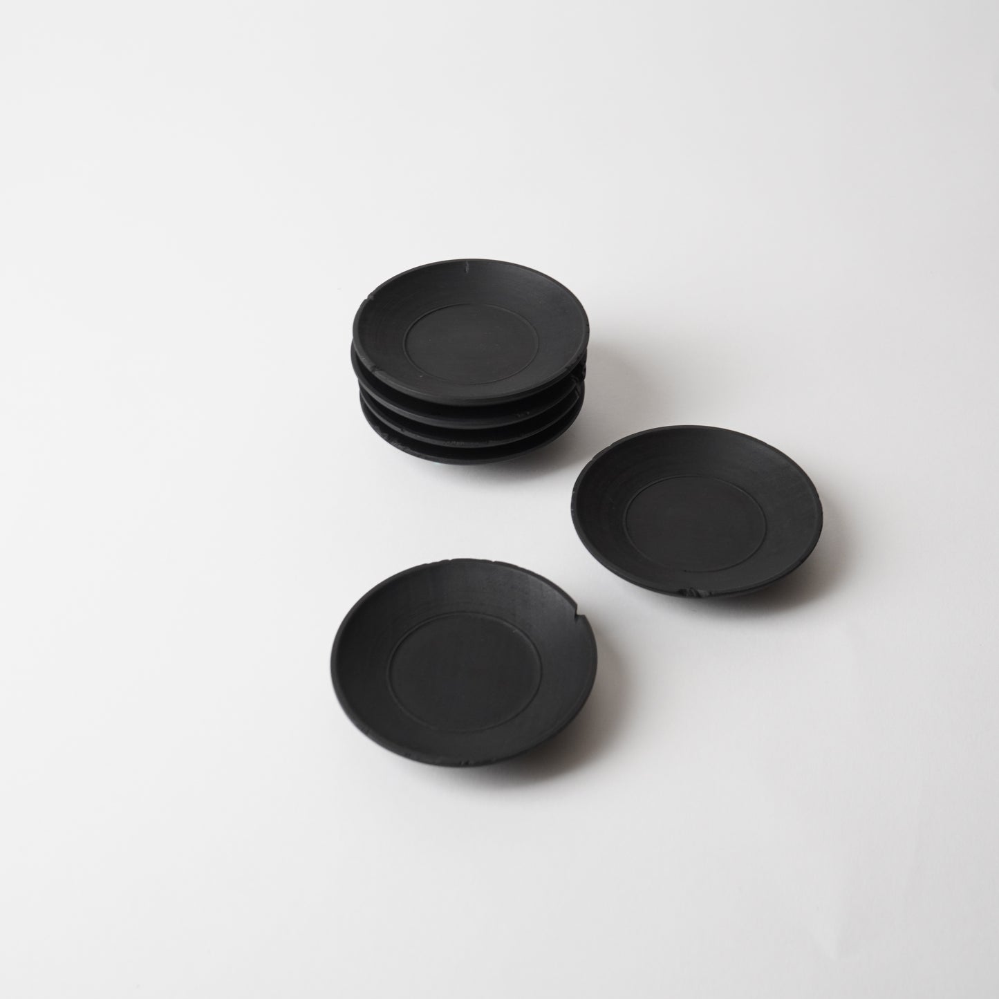 Set of black  wooden saucer on a white background. Handmade wooden saucer by Japanese artist at Gallery tete Hong Kong.