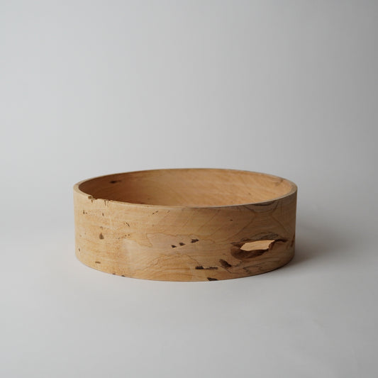 Wooden bowl with natural grain and texture on a light gray background