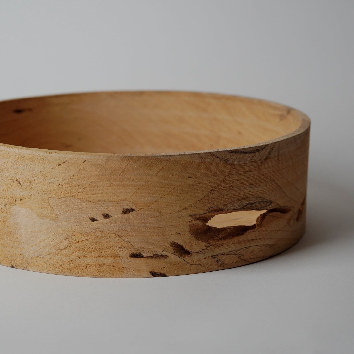 Wooden bowl with natural grain and texture on a plain background