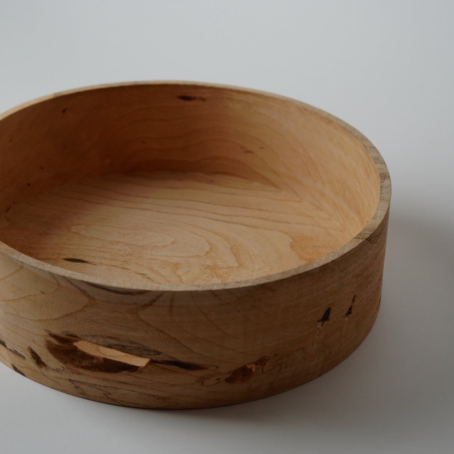 Wooden bowl with natural grain and texture on a white background