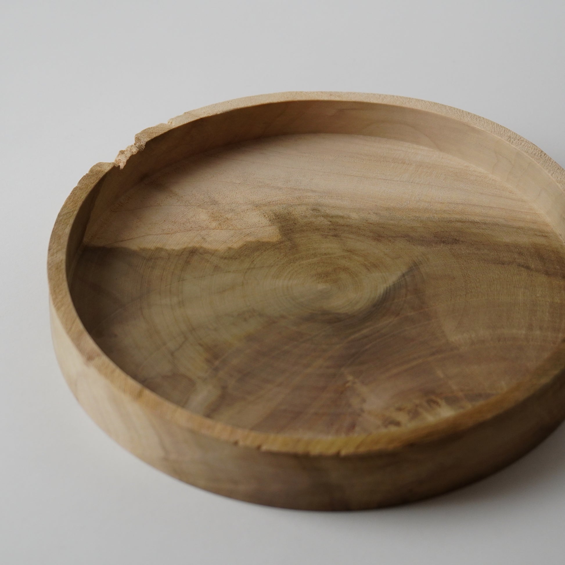 Wooden bowl with natural grain on a light gray background