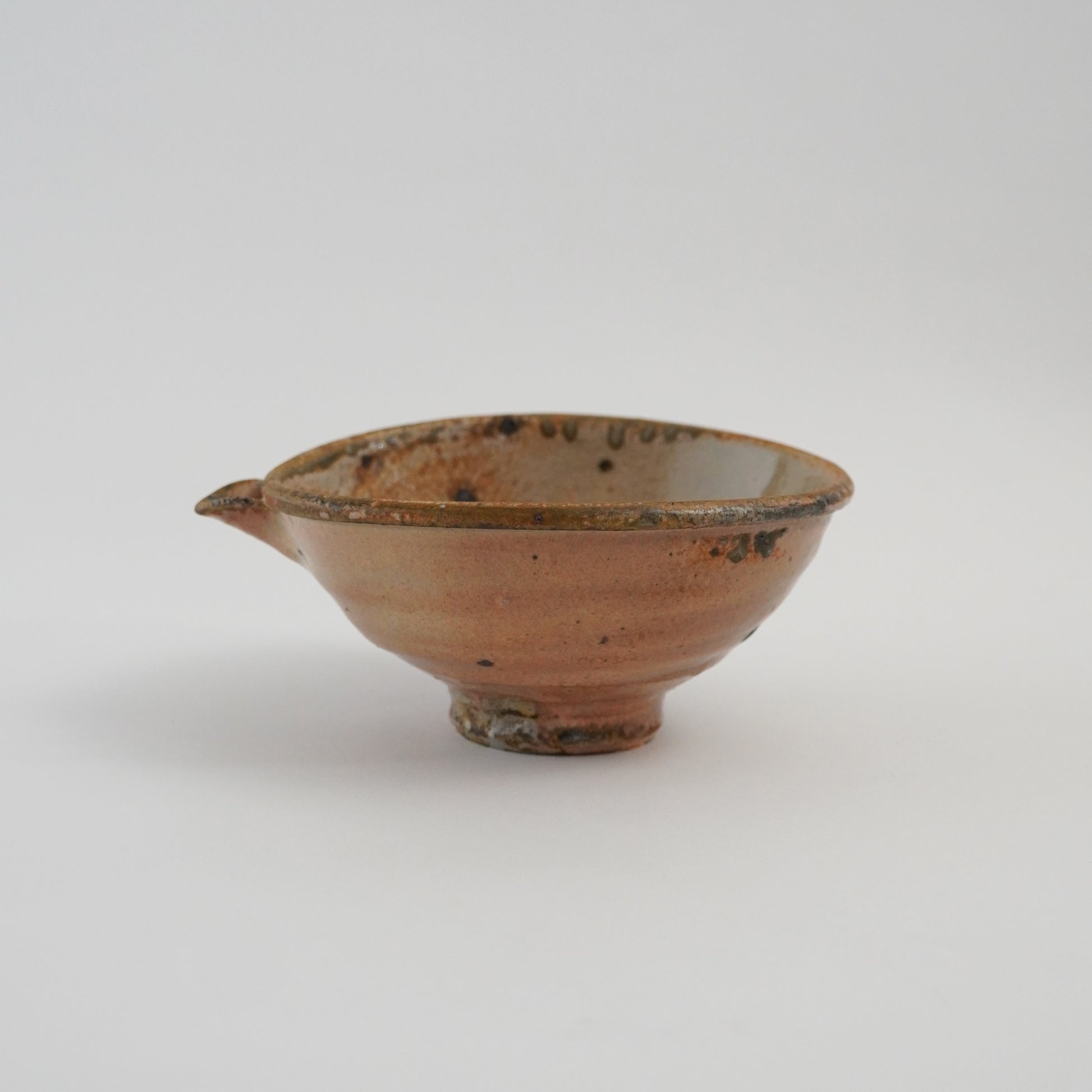 Ceramic bowl with brownish-red glaze on a white background