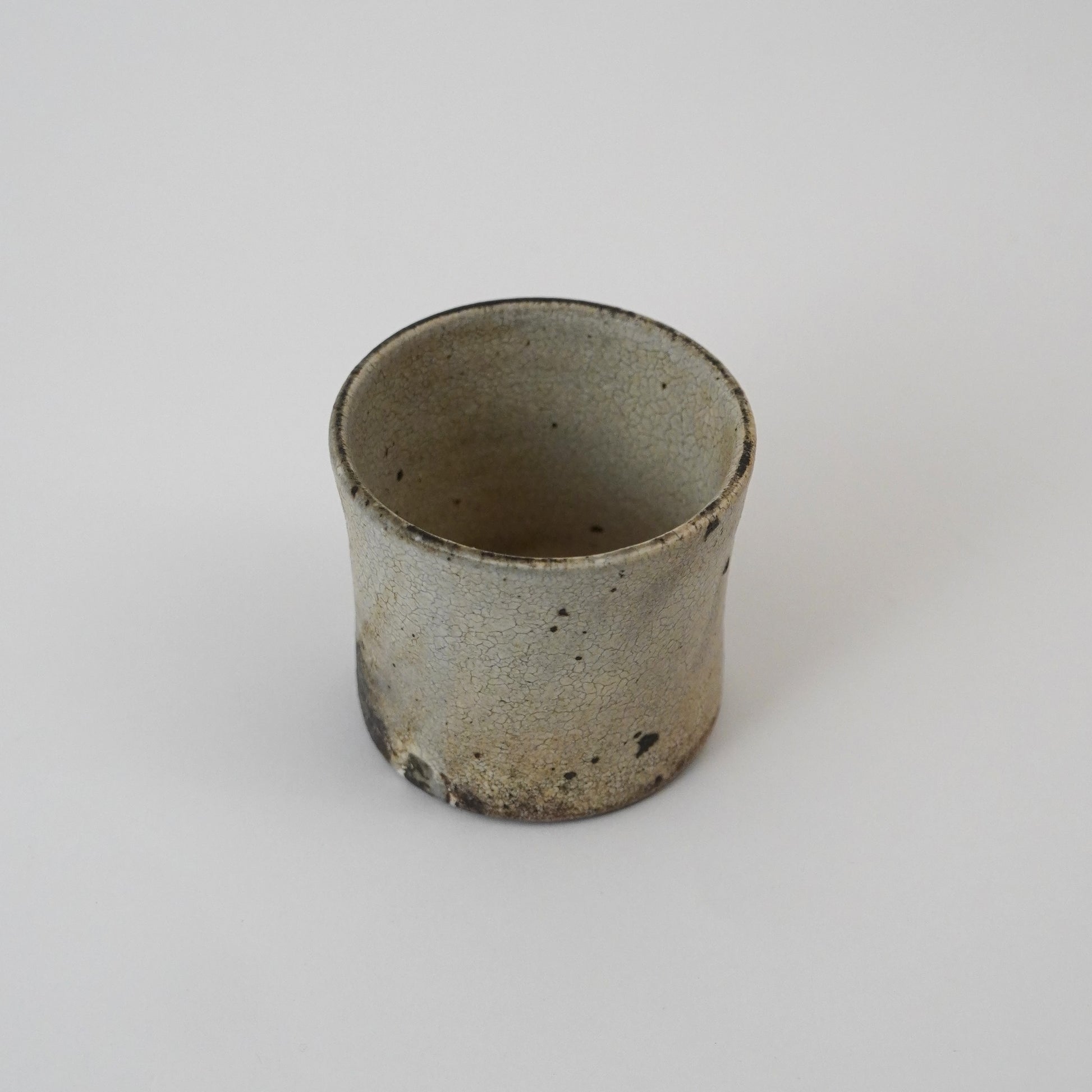 Ceramic cup with a textured surface on a white background. Handmade ceramic cup by Japanese artist at Gallery tete Hong Kong.