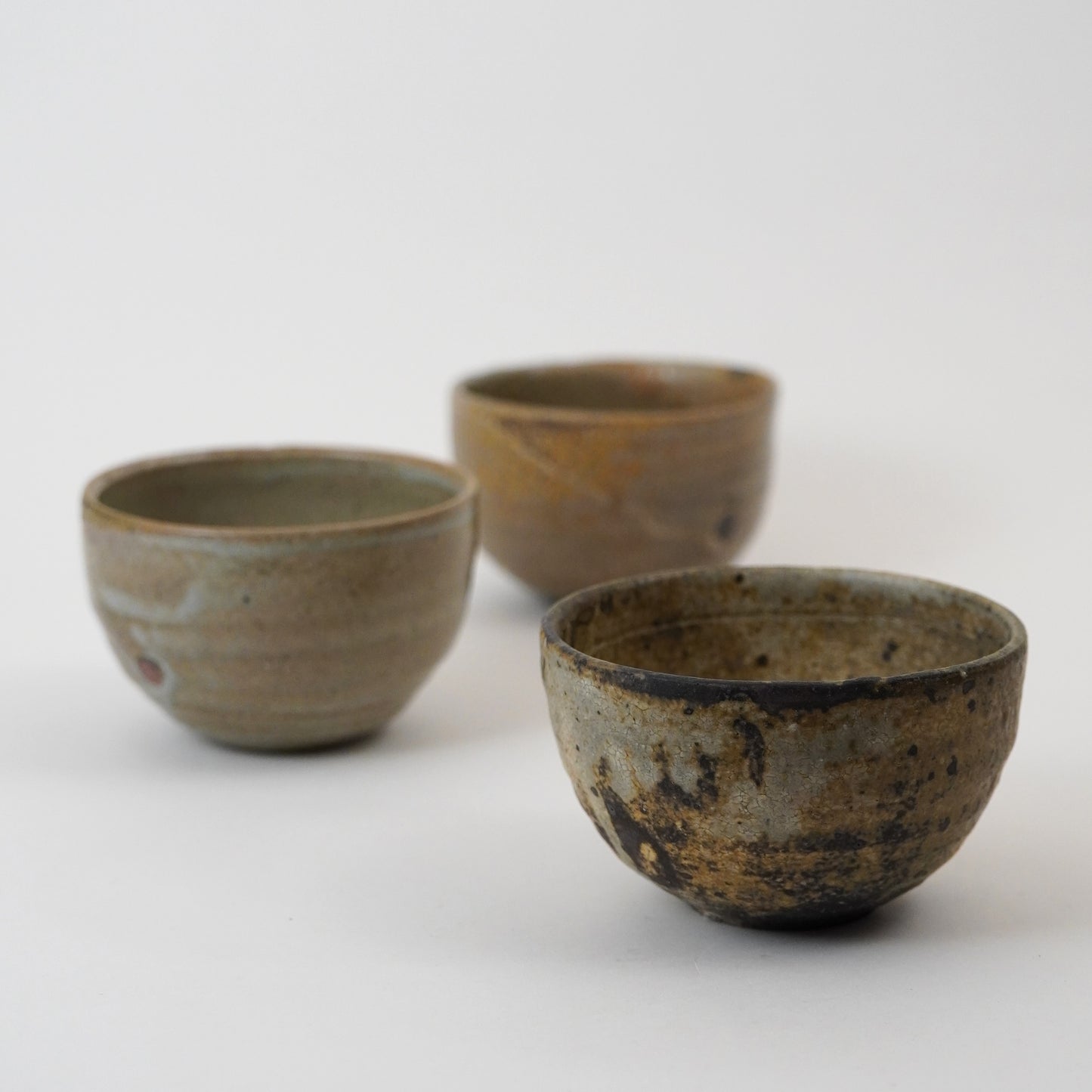 Three ceramic bowls with rustic textures on a white background