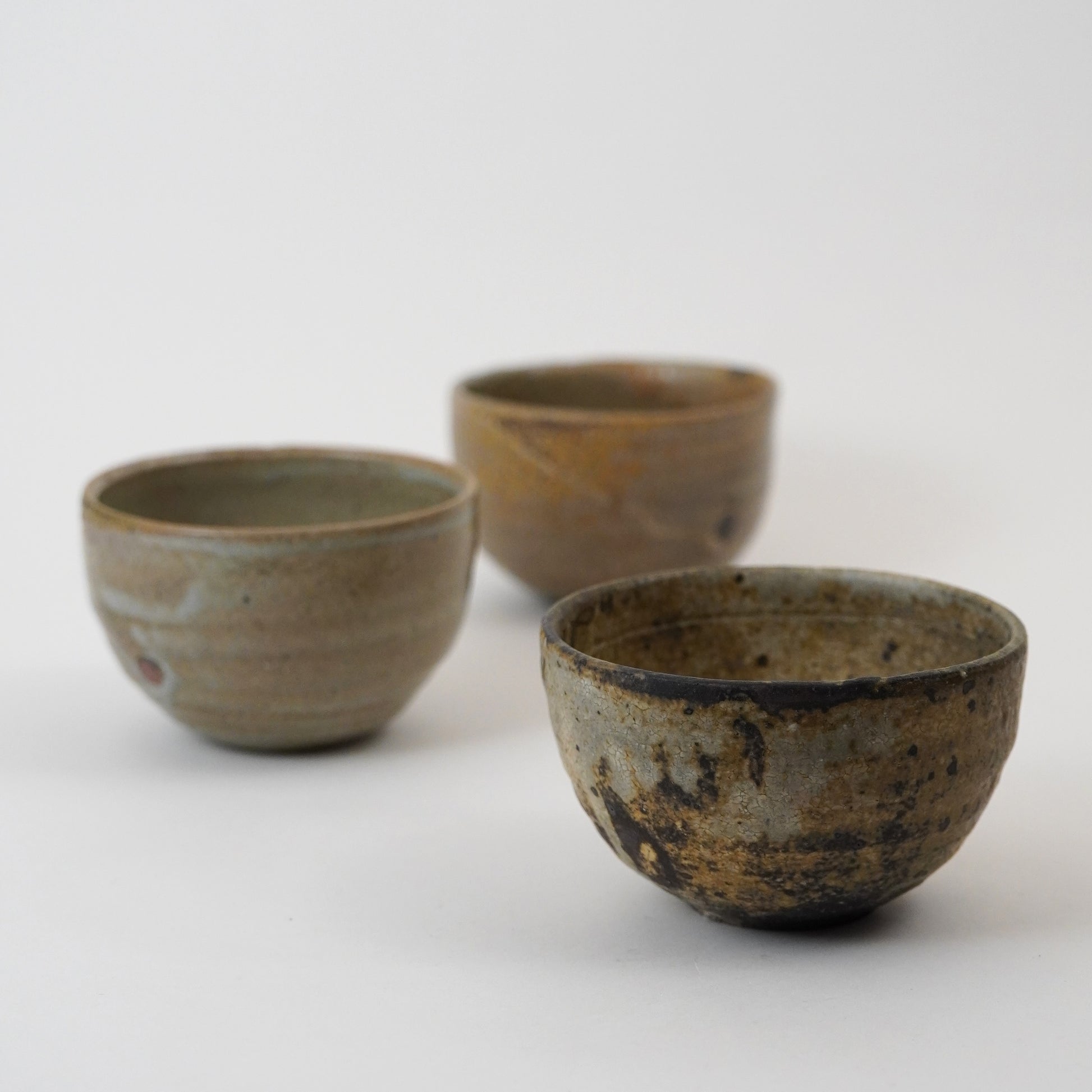 Three ceramic bowls with rustic textures on a white background