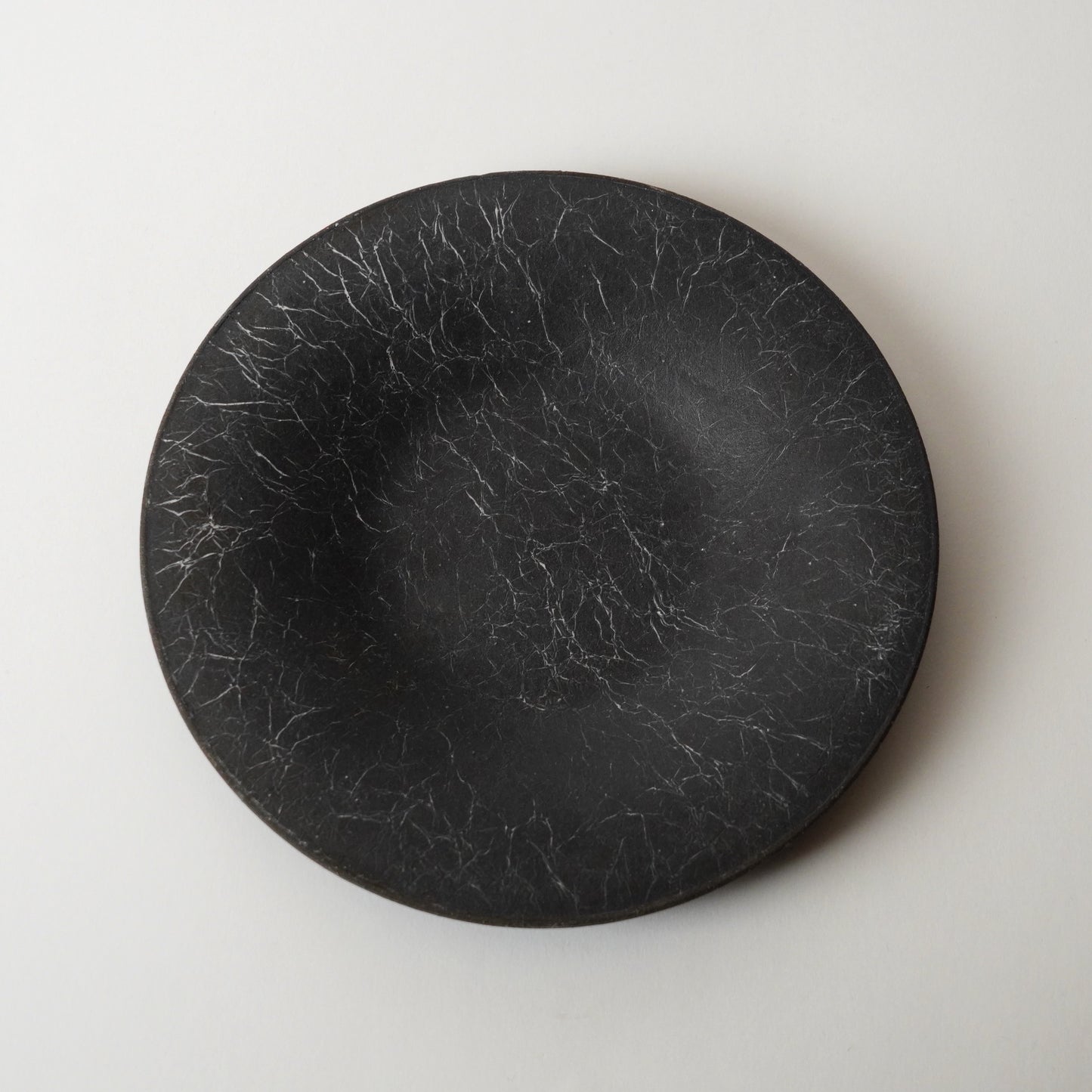 Black round stone plate on a light gray background
