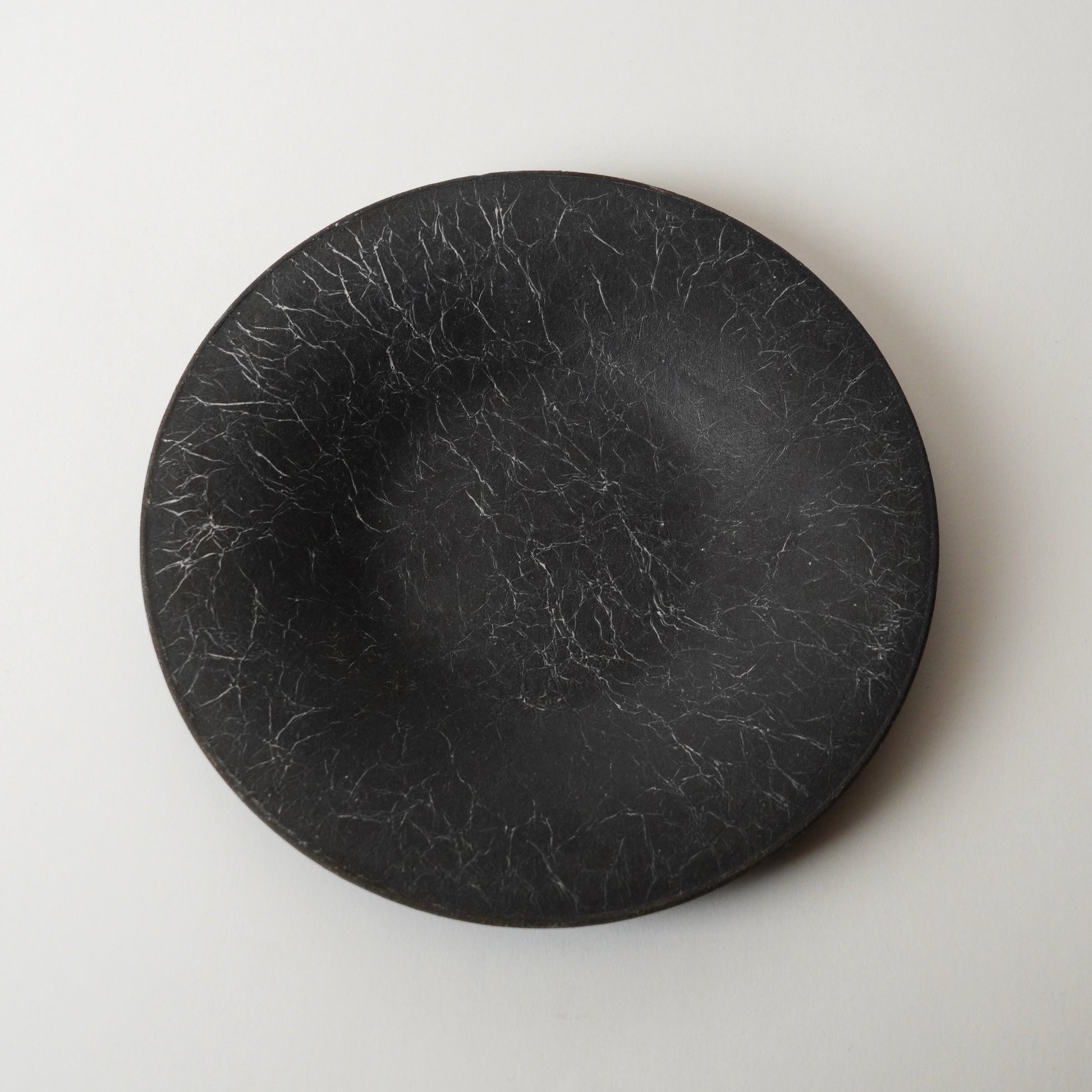 Black round stone plate on a light gray background