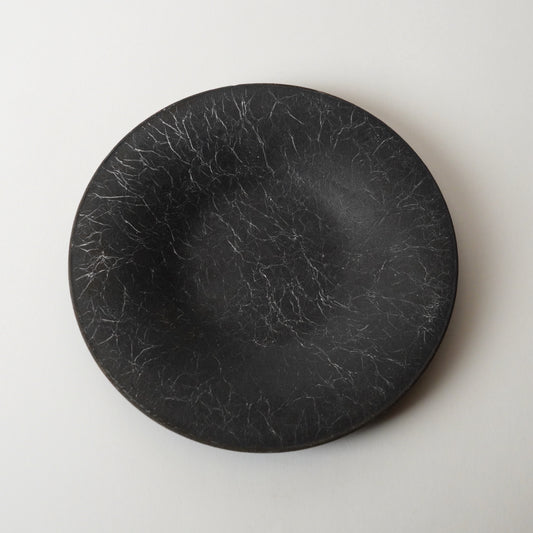 Black round stone plate on a light gray background