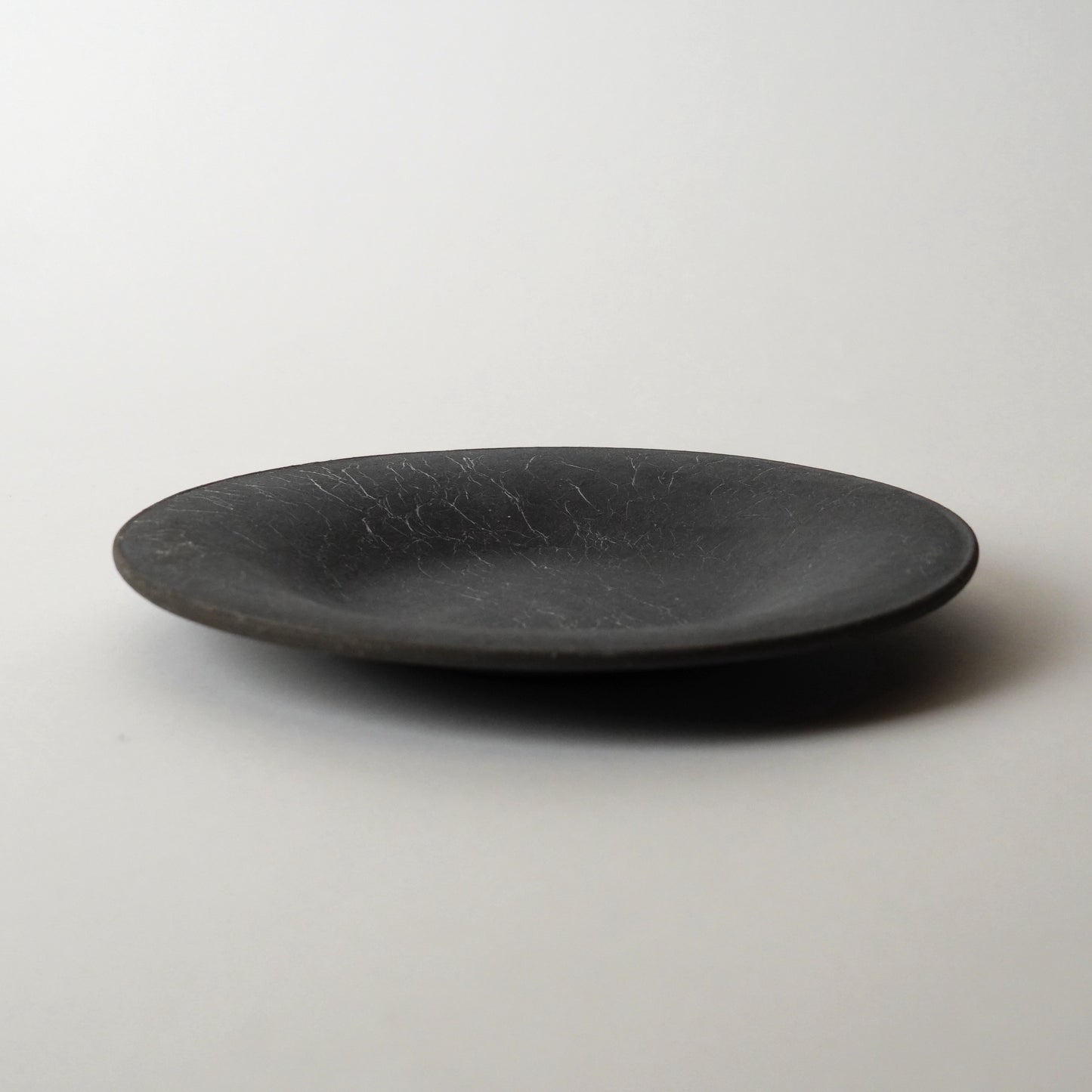 Black ceramic plate on a white background