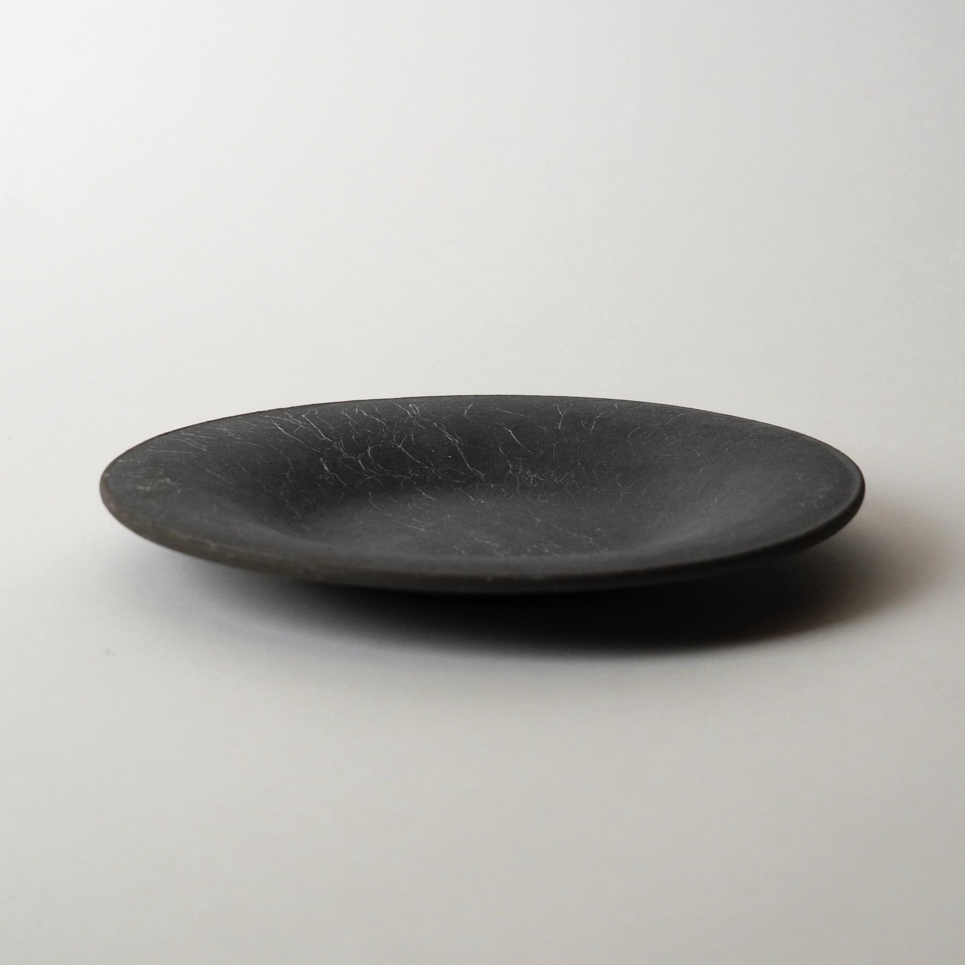 Black ceramic plate on a white background