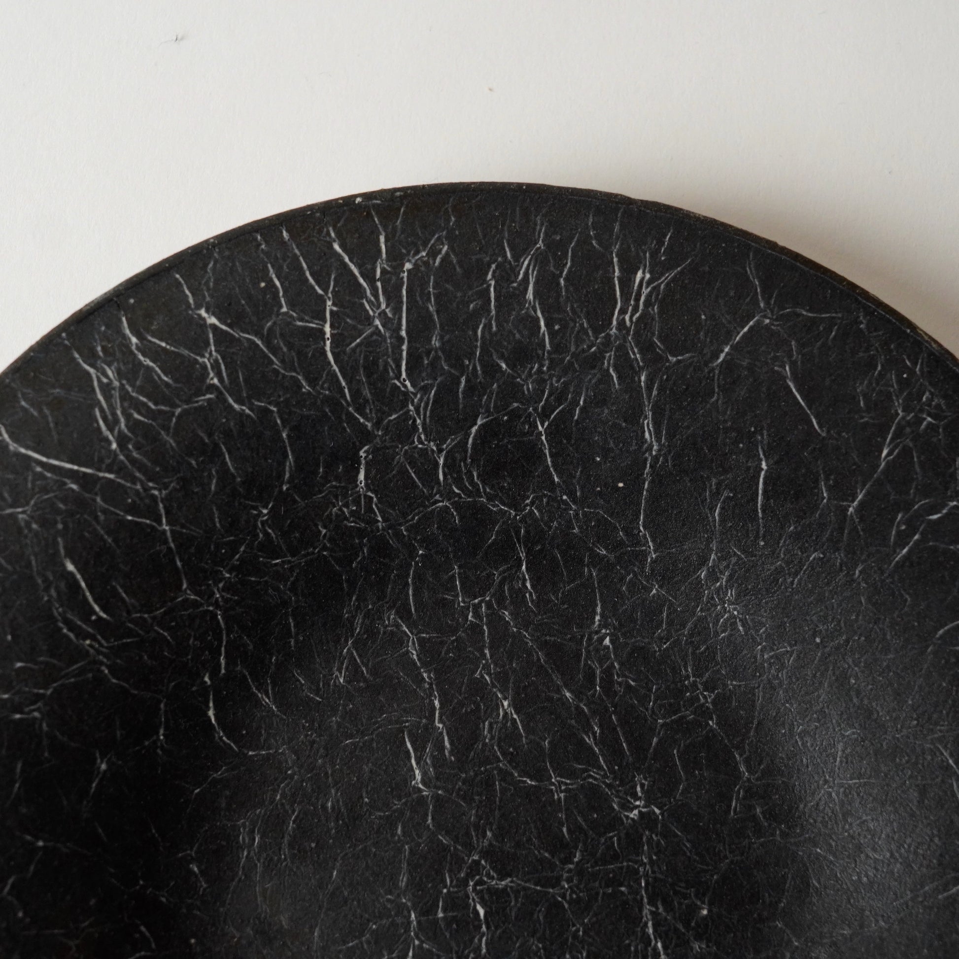Close-up of a black, cracked surface on a white background