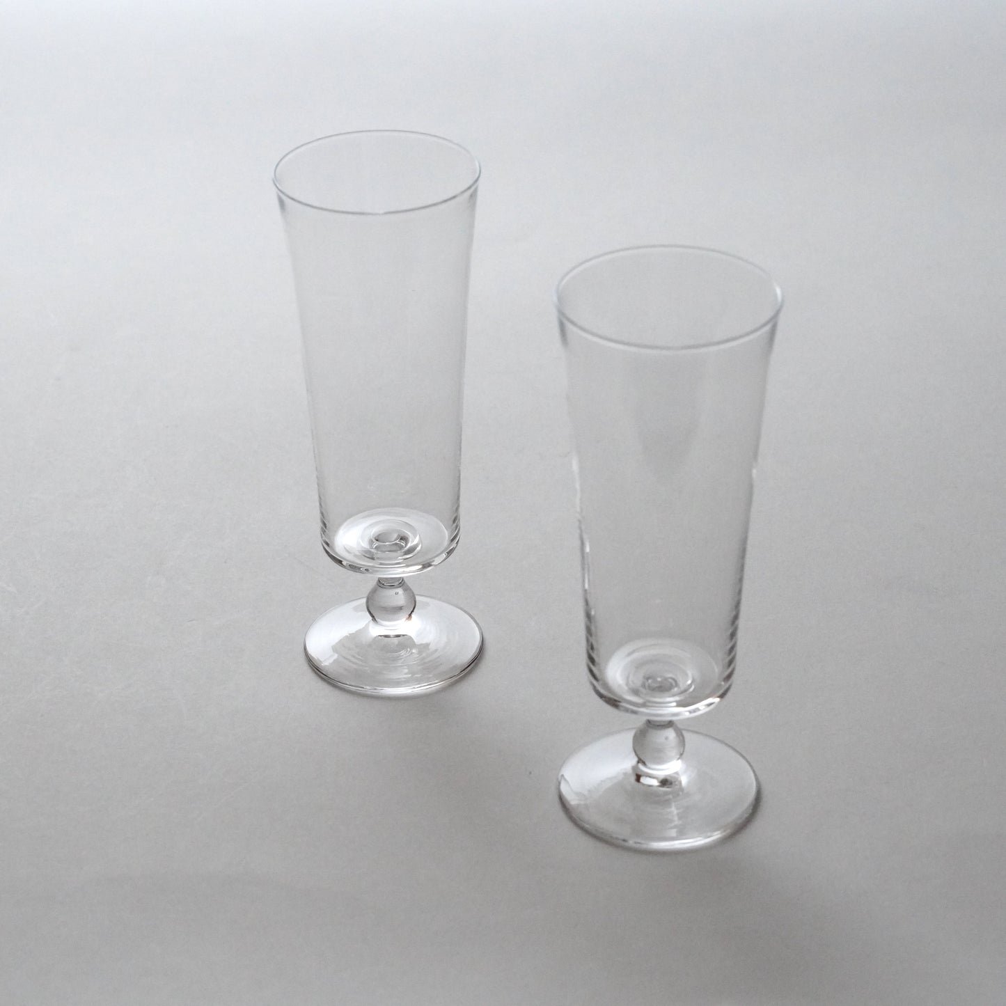 Two clear glass goblets on a light gray background. Handmade glass by Japanese artist at Gallery tete Hong Kong.
