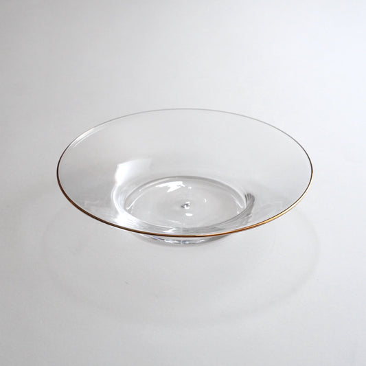 A clear glass plate with a gold rim on the edge, displayed against a neutral background.