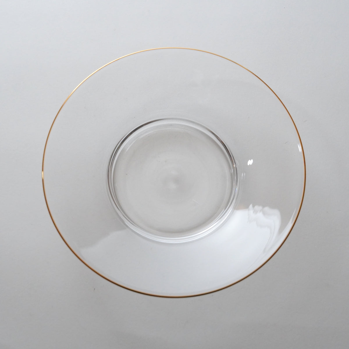 Clear glass bowl with gold rim on a white background