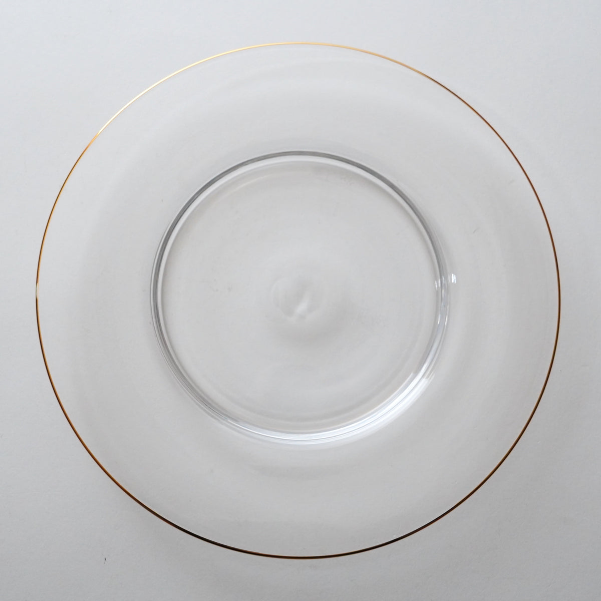 A clear glass plate with a gold rim.