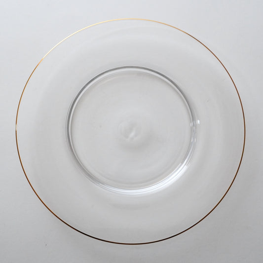 A clear glass plate with a gold rim.