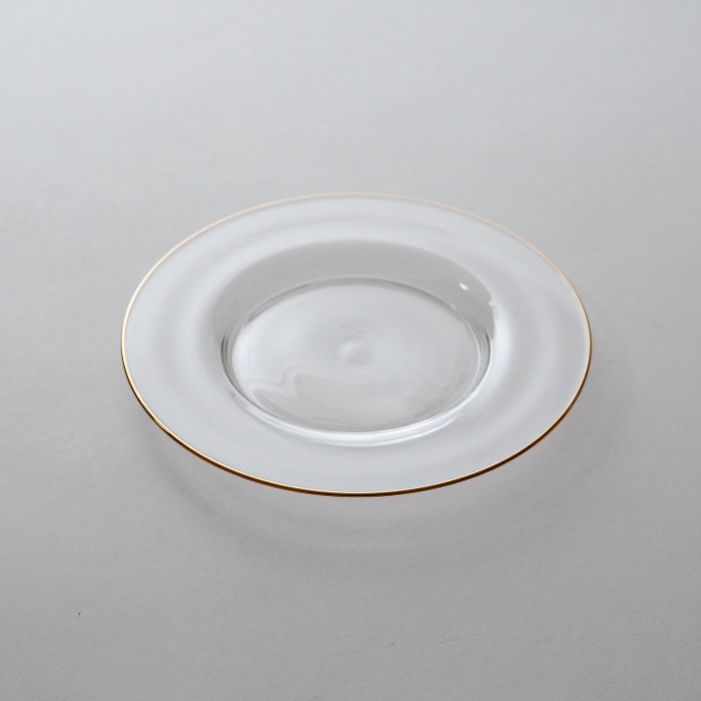 White plate with gold rim on a light gray background