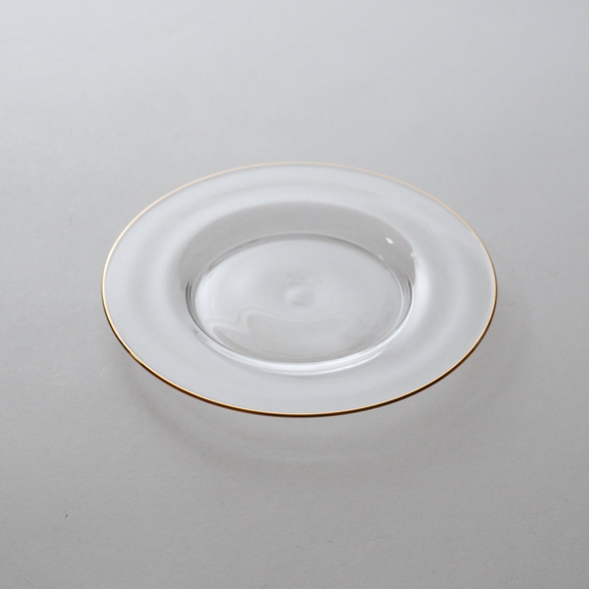 White plate with gold rim on a light gray background