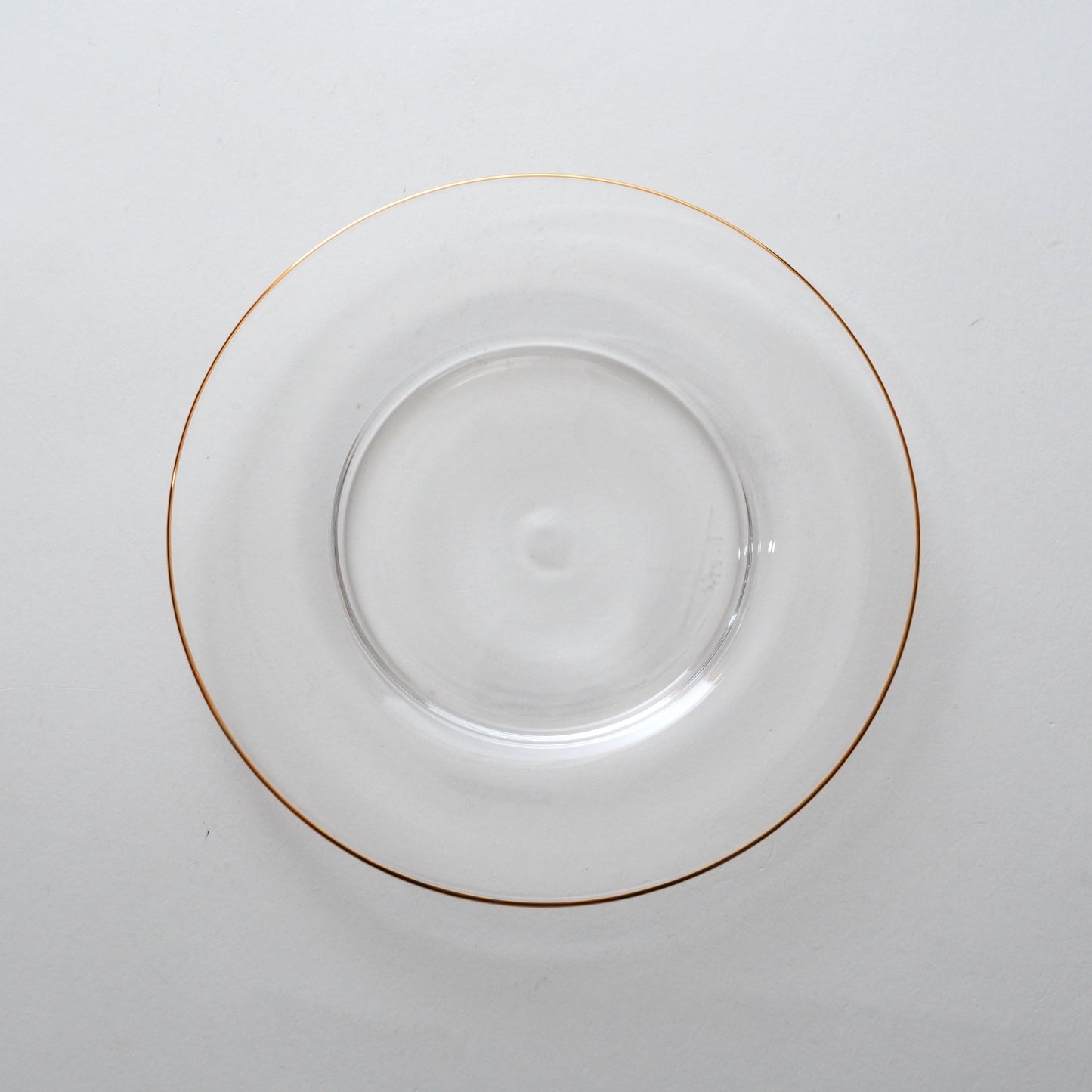 A clear glass plate with a golden rim.