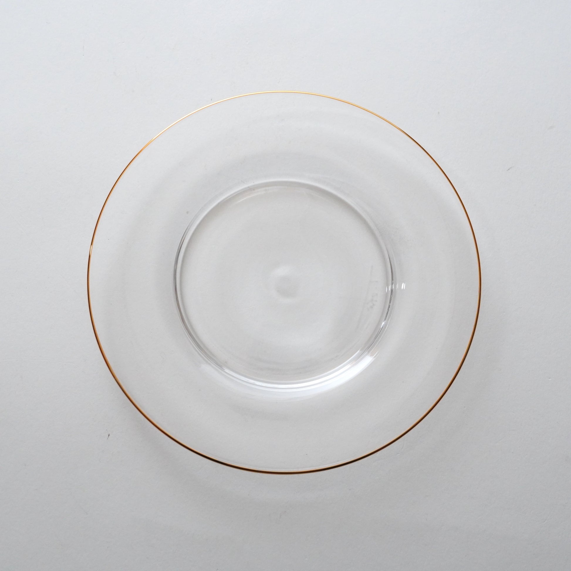 A clear glass plate with a golden rim.