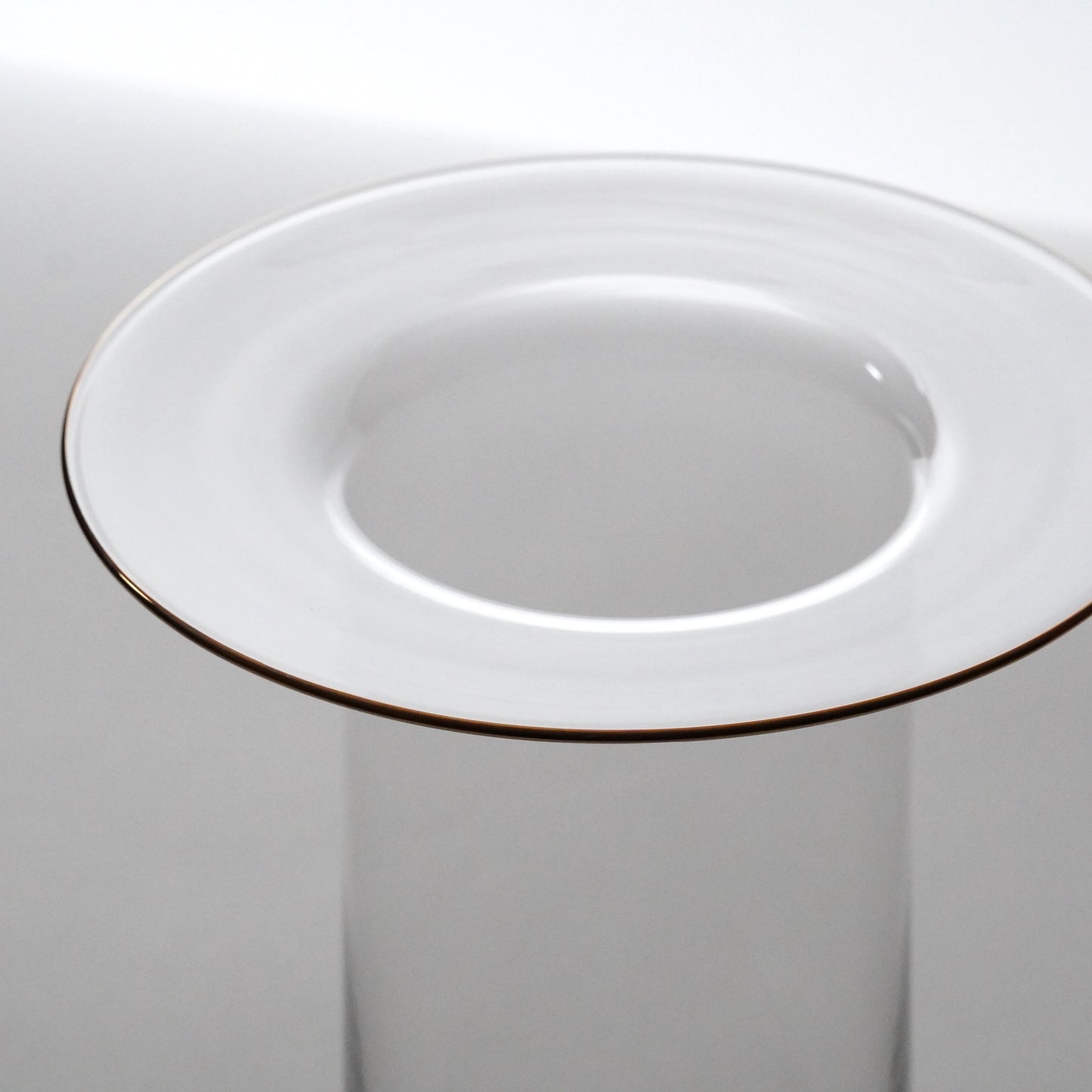 Glass with a gold rim on a plain background