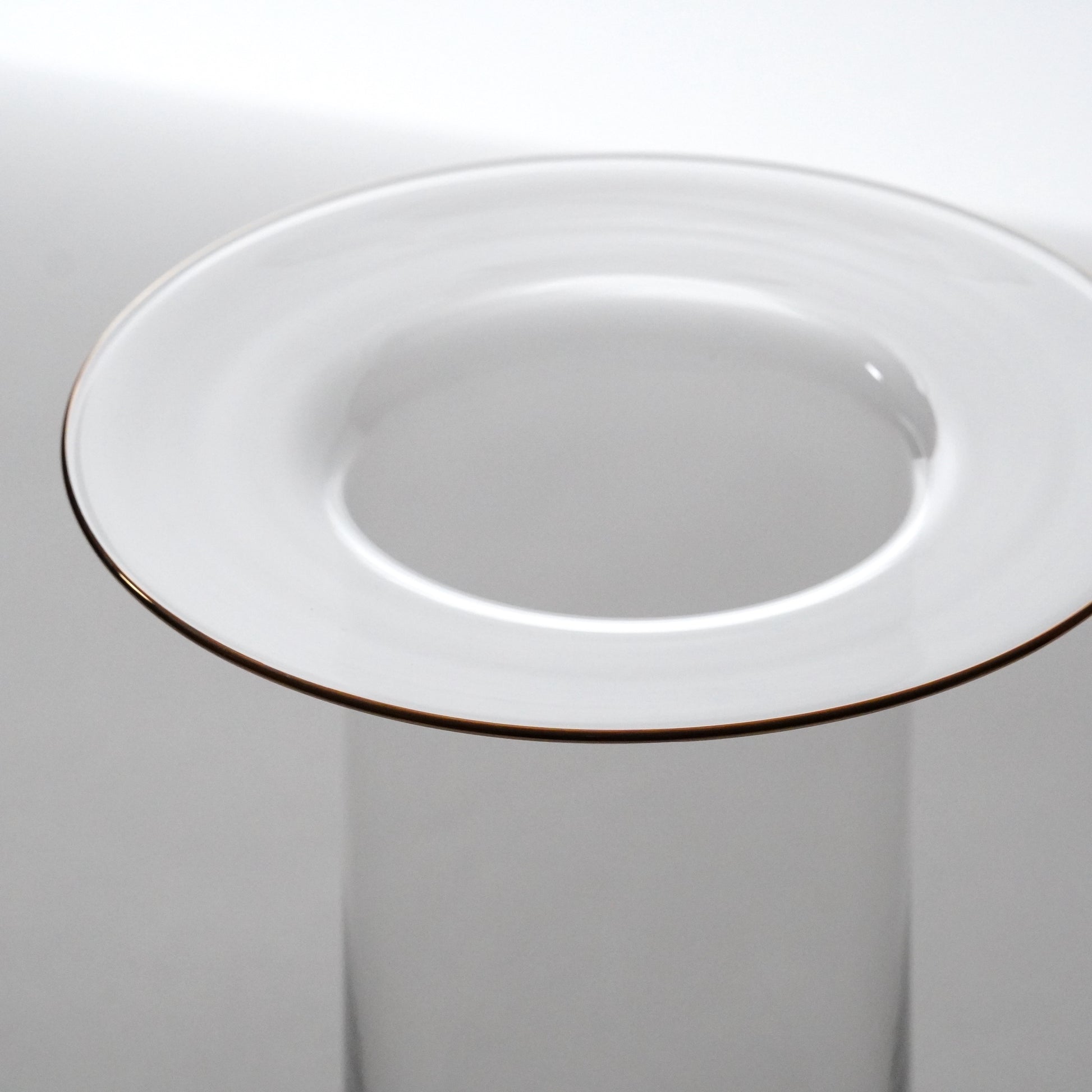 Glass with a gold rim on a plain background