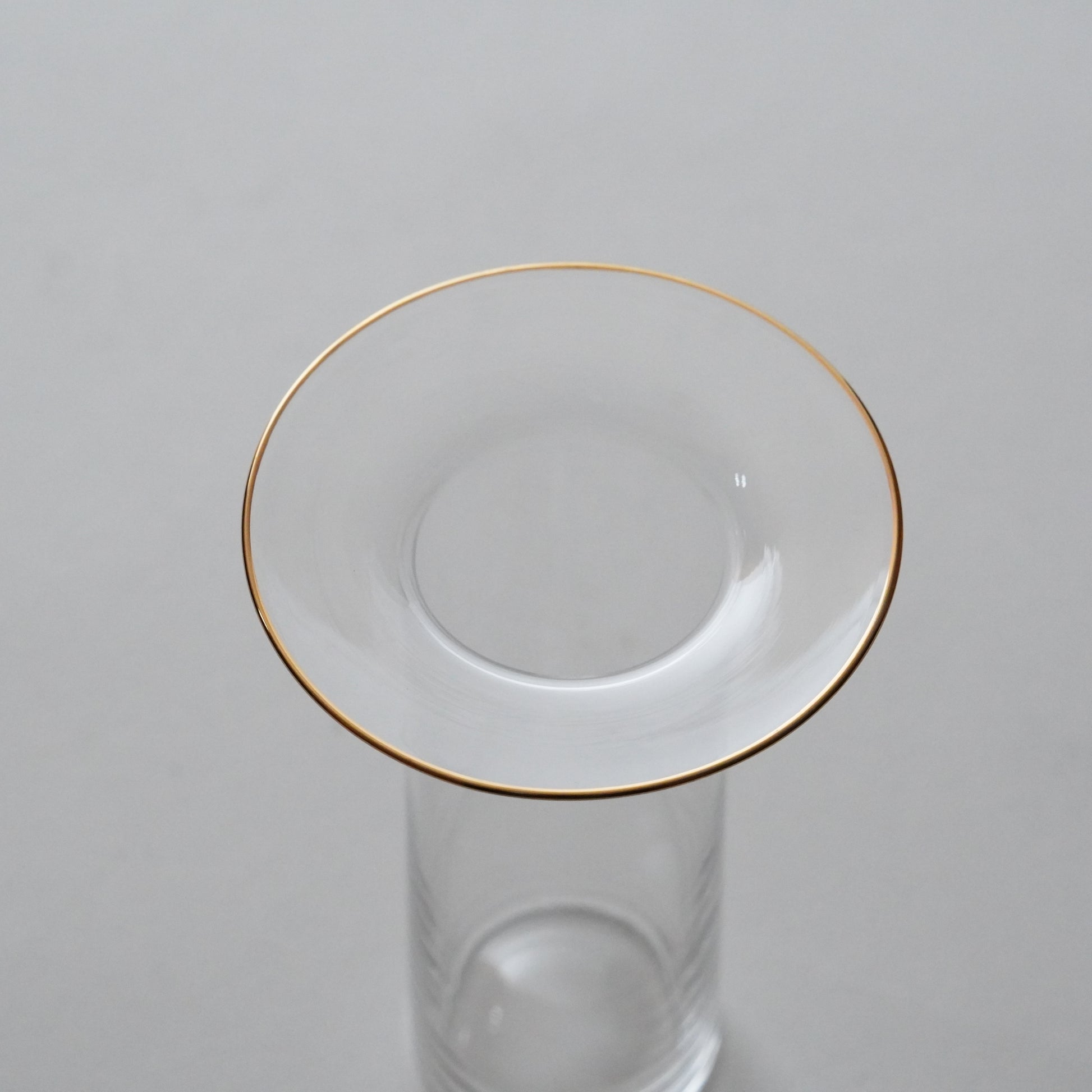 Clear glass with gold rim on gray background