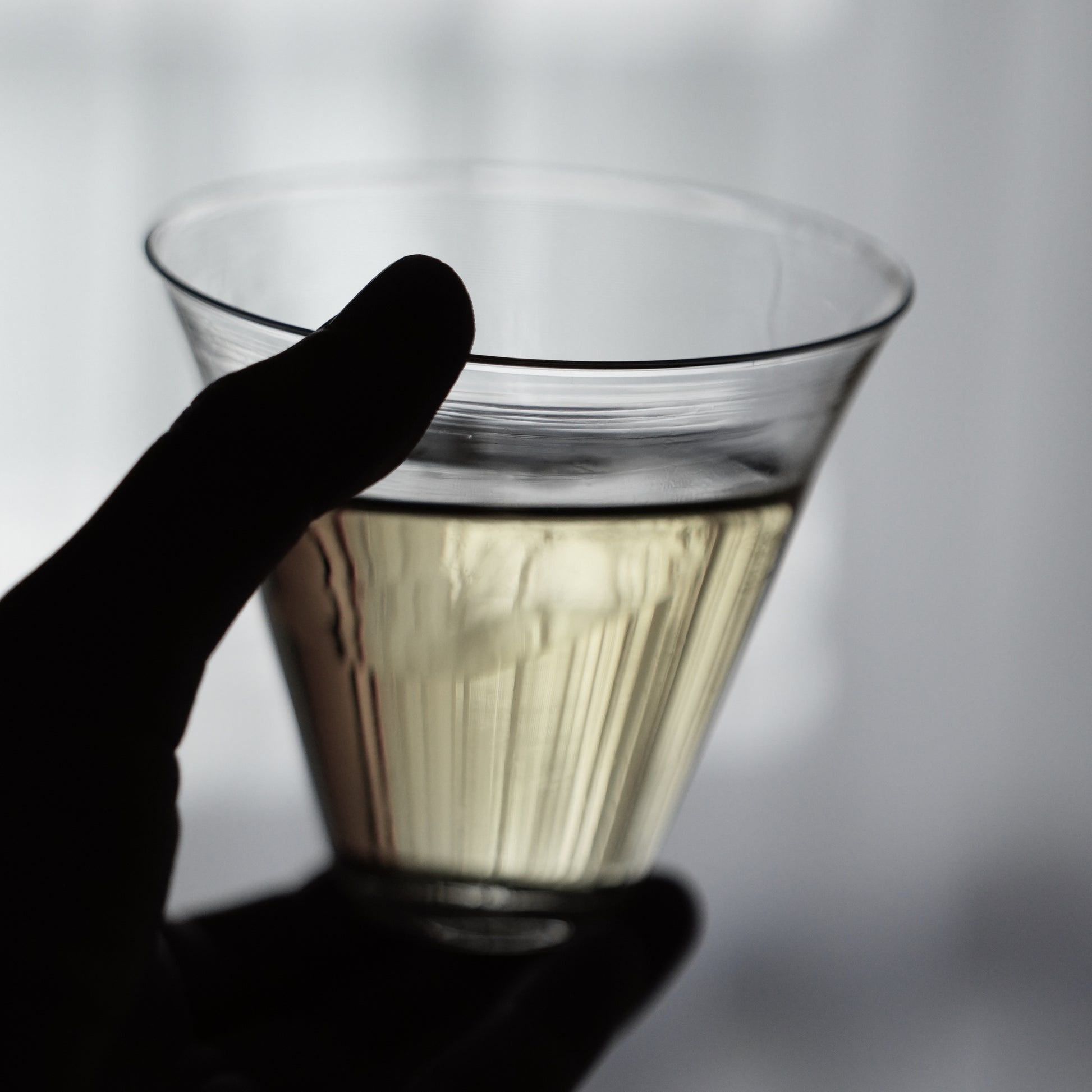 Hand holding a glass of champagne with a blurred background