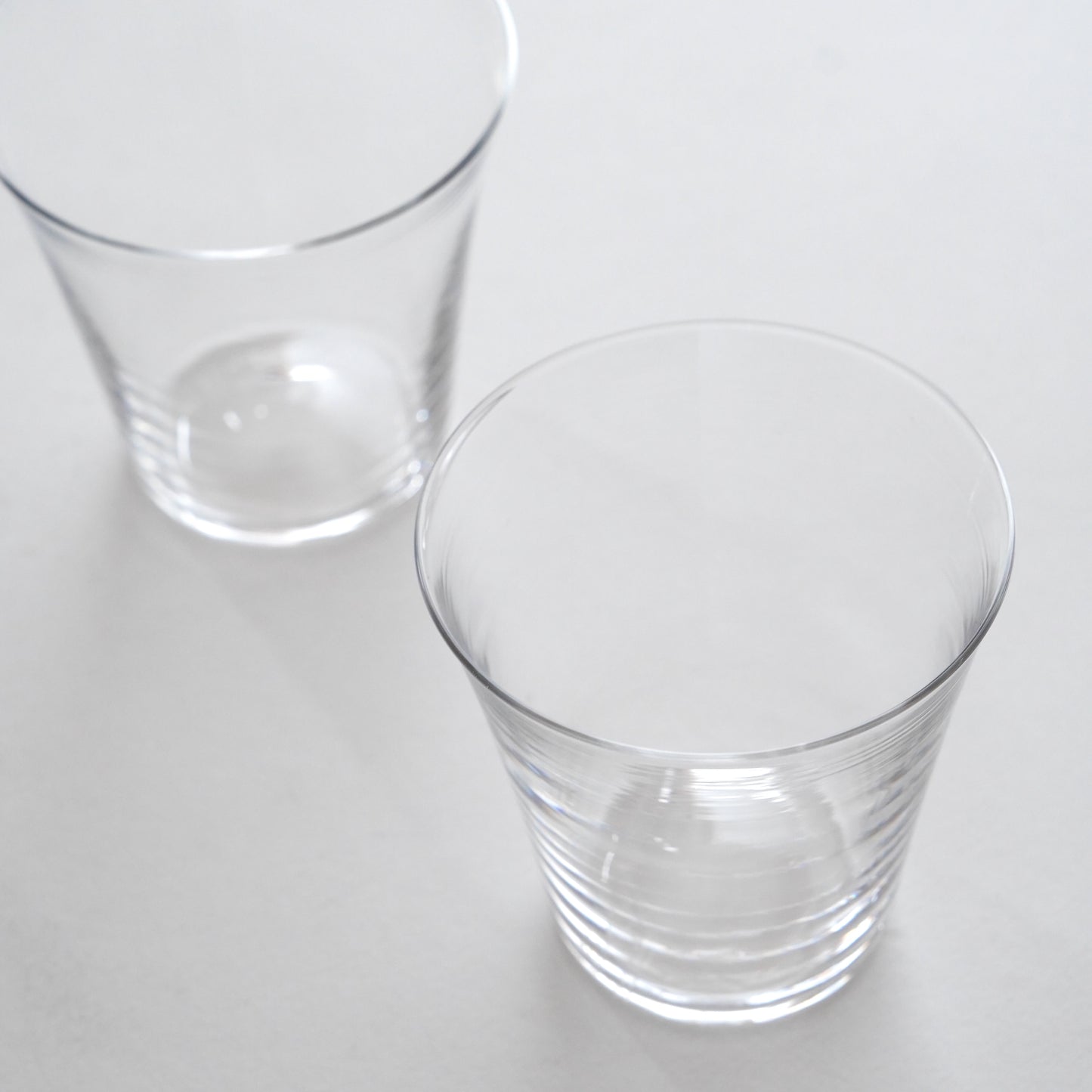 Two clear glass tumblers on a white background