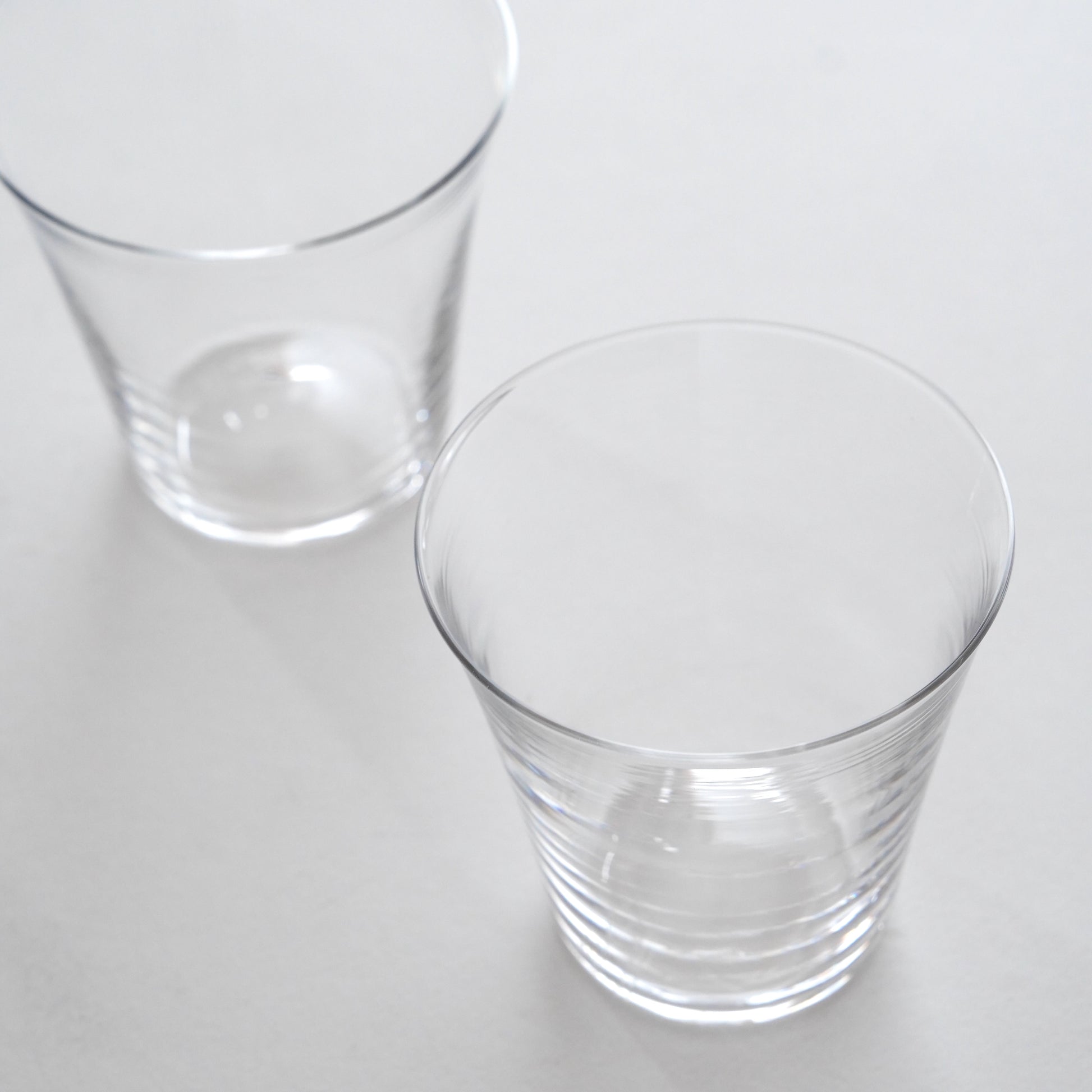 Two clear glass tumblers on a white background