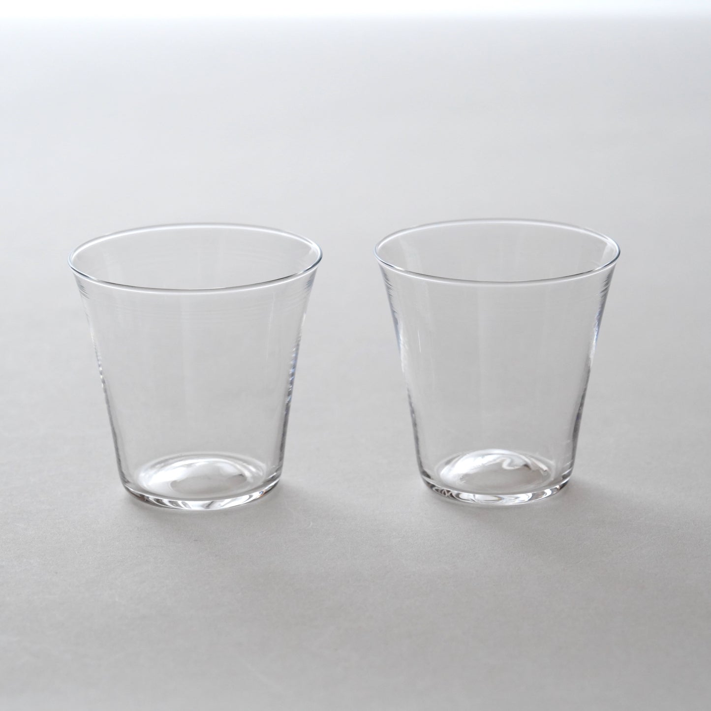 Two clear glass tumblers on a white background