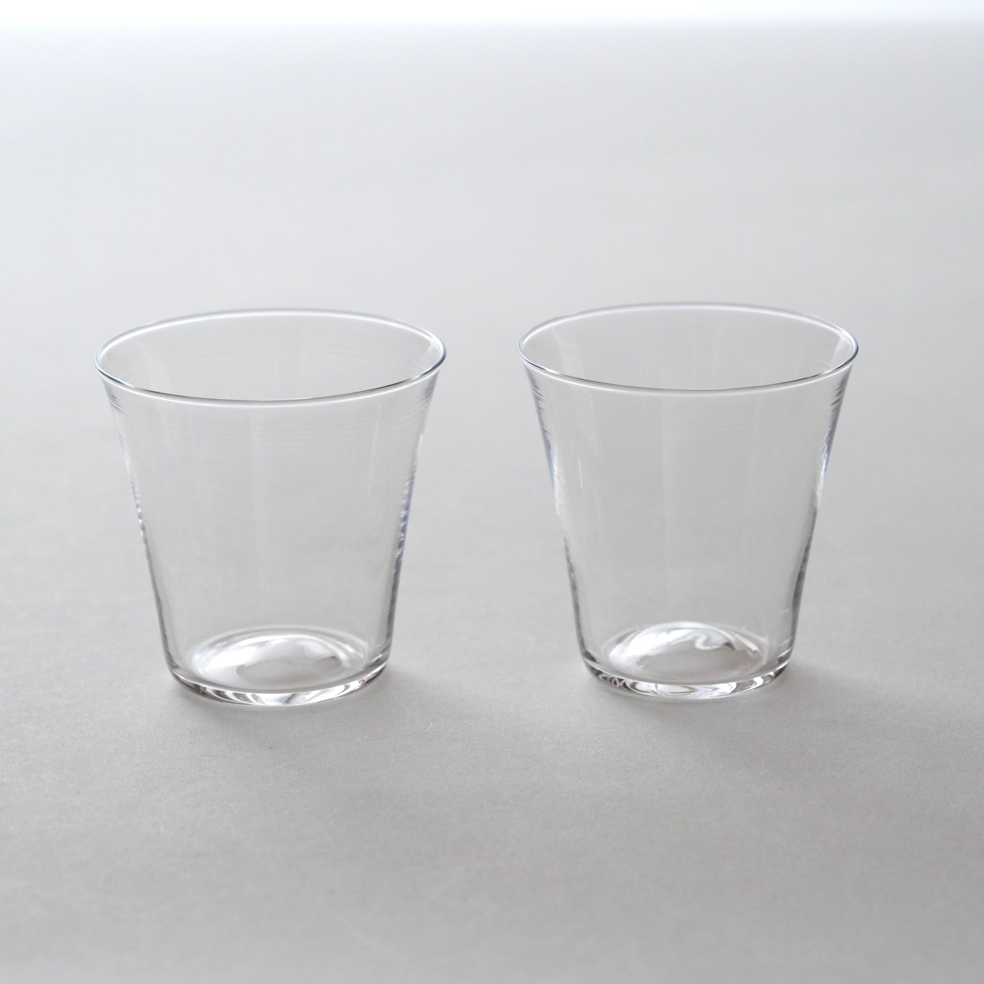Two clear glass tumblers on a white background